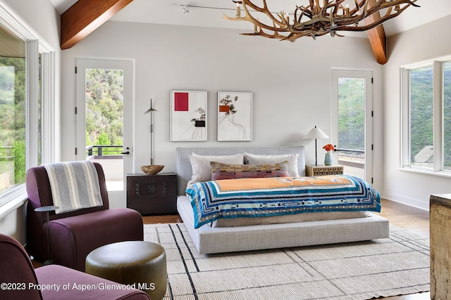 bedroom featuring lofted ceiling with beams, a chandelier, and light wood-type flooring