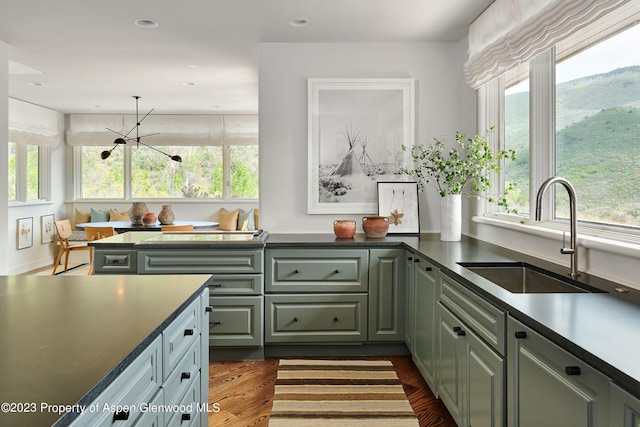 kitchen featuring breakfast area, dark hardwood / wood-style floors, a notable chandelier, and sink