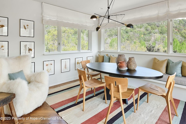 sunroom with breakfast area and an inviting chandelier