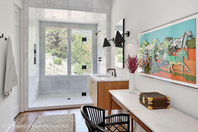 bathroom with hardwood / wood-style floors, vanity, and walk in shower