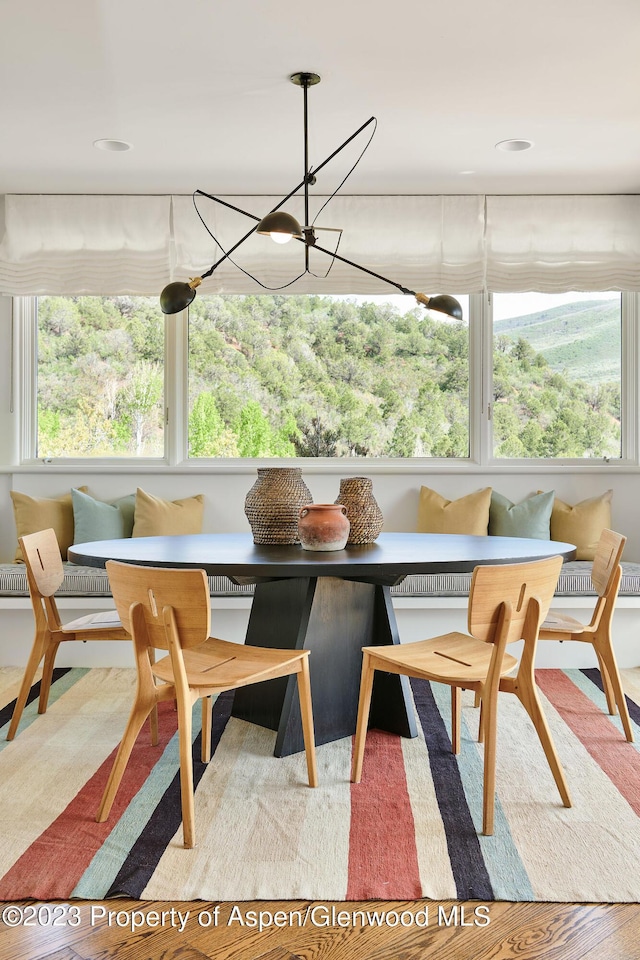 sunroom with breakfast area and a chandelier