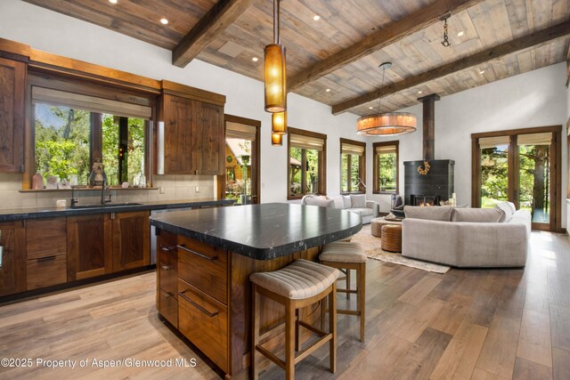 2701 County Rd 100, Carbondale, CO 81623 - kitchen featuring wood ceiling with exposed beams, a sink, dark countertops, a breakfast bar, and plenty of natural light