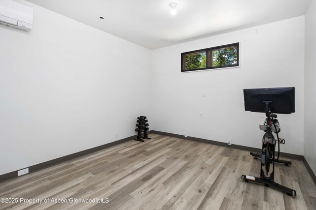 2701 County Rd 100, Carbondale, CO 81623 - workout room with a wall unit AC, light wood-type flooring, and baseboards