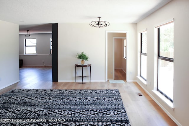 560 Willowwood Ln, Delta, CO 81416 - unfurnished room featuring light wood-style flooring and a chandelier