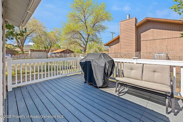 deck featuring grilling area and fence