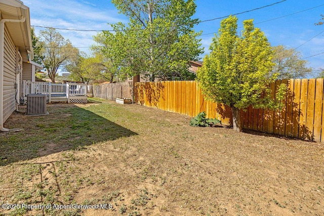 view of yard featuring a wooden deck and central AC