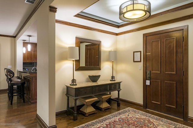 foyer entrance with dark hardwood / wood-style flooring, ornamental molding, and sink