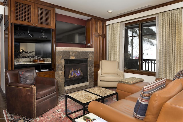 living room featuring a stone fireplace and ornamental molding