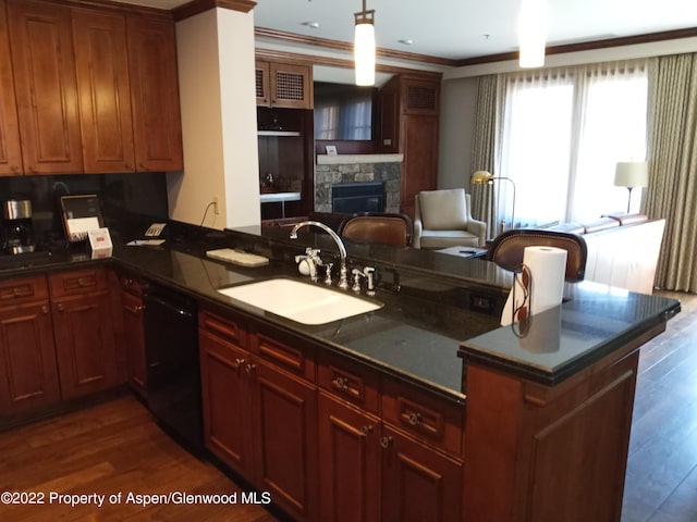 kitchen with dishwasher, a stone fireplace, sink, ornamental molding, and dark hardwood / wood-style flooring