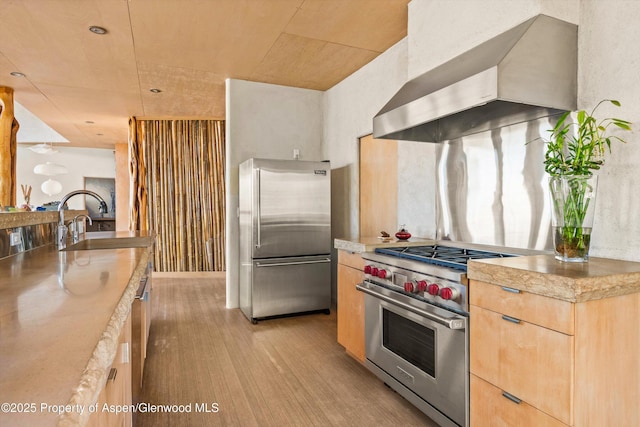 515 Park Cir, Aspen, CO 81611 - kitchen with high quality appliances, wall chimney exhaust hood, light brown cabinets, light countertops, and a sink