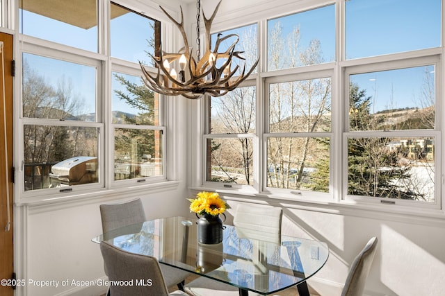 sunroom / solarium featuring a notable chandelier