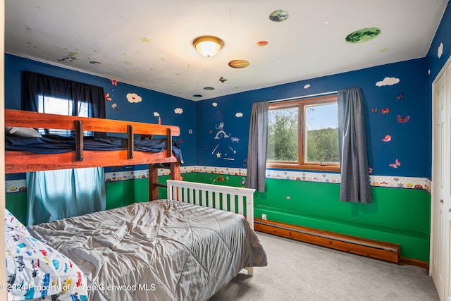 bedroom with carpet flooring, multiple windows, and a baseboard heating unit