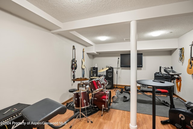 exercise room with hardwood / wood-style flooring and a textured ceiling