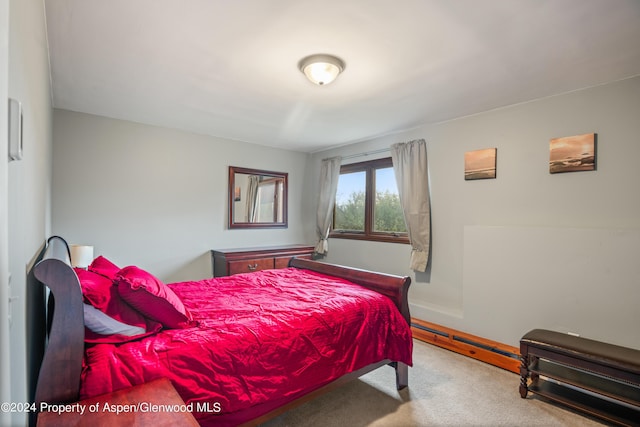 carpeted bedroom featuring a baseboard heating unit