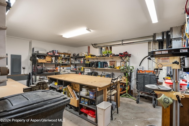 garage with a workshop area and electric panel