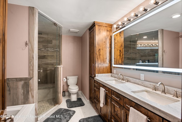 bathroom featuring tile patterned flooring, vanity, toilet, and an enclosed shower