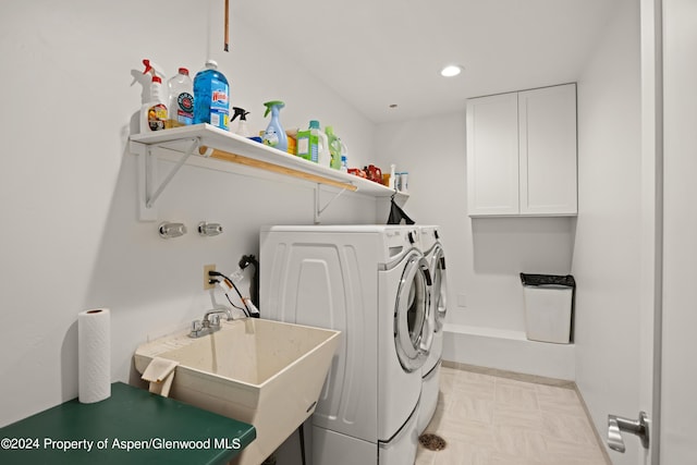 washroom featuring cabinets, independent washer and dryer, and sink