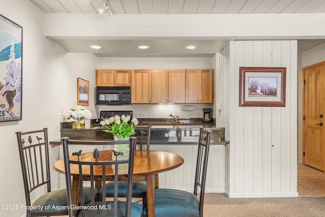131 E Durant Ave Unit 104, Aspen, CO 81611 - kitchen with black microwave, dark countertops, light brown cabinetry, wooden ceiling, and wood walls