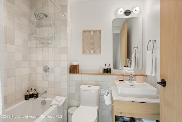 full bathroom with vanity, tiled shower / bath, tile walls, and toilet