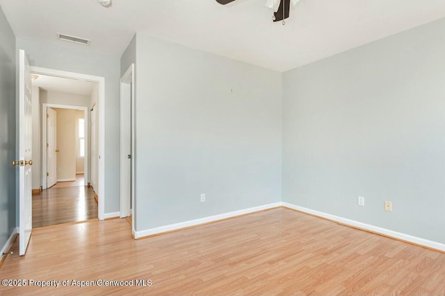 unfurnished room featuring visible vents, a ceiling fan, light wood-style flooring, and baseboards