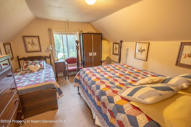 bedroom featuring carpet, a textured ceiling, and vaulted ceiling