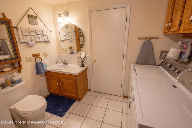 bathroom with washing machine and dryer, tile patterned flooring, vanity, and toilet