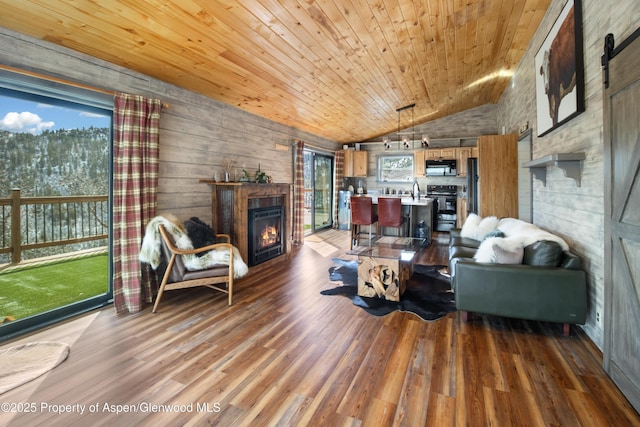 living room featuring a warm lit fireplace, lofted ceiling, wooden ceiling, and light wood finished floors