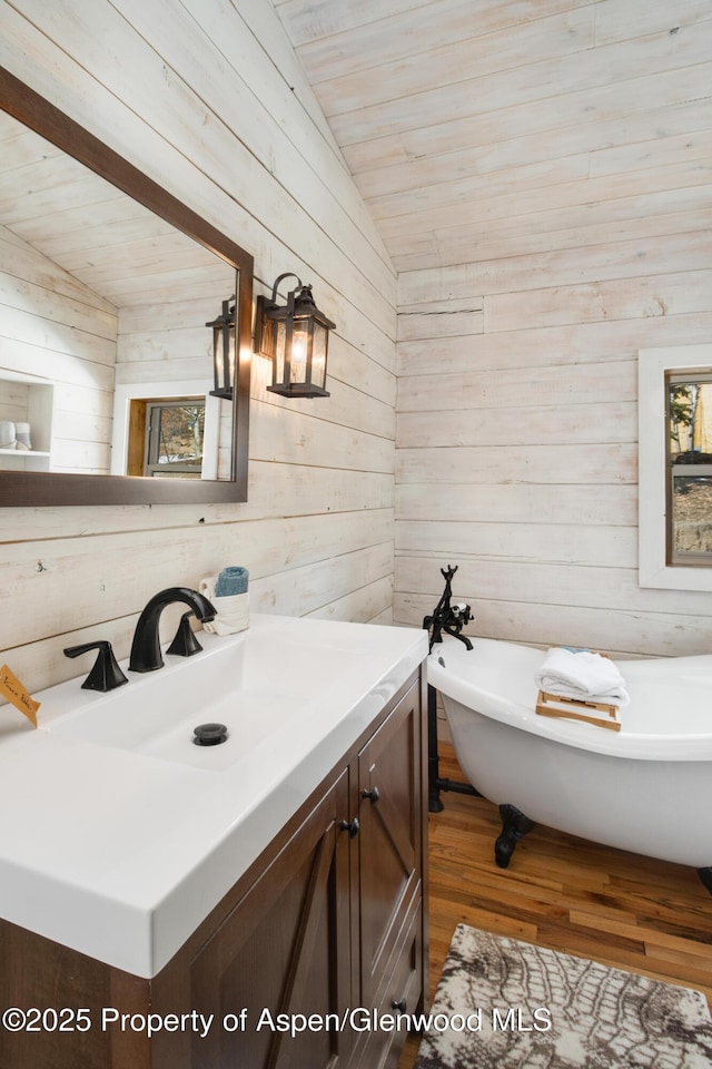 bathroom featuring wooden walls, a soaking tub, wood ceiling, vaulted ceiling, and vanity