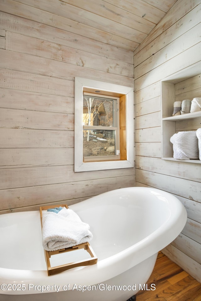 bathroom with a freestanding tub, wooden ceiling, wood walls, and wood finished floors