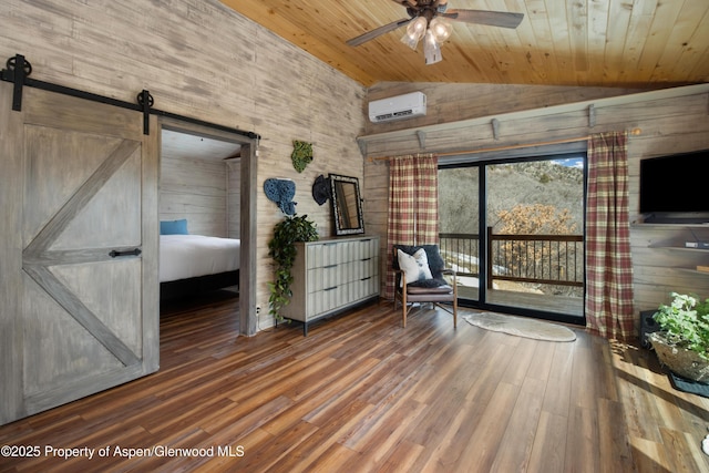 unfurnished room featuring a barn door, a wall mounted AC, vaulted ceiling, wood finished floors, and wooden ceiling