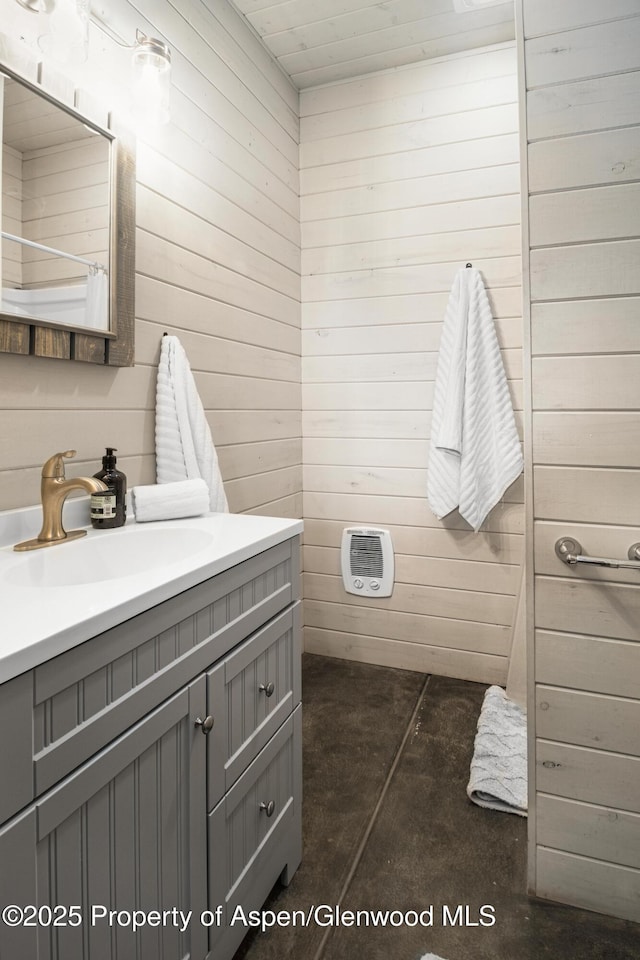 bathroom featuring concrete floors, wood walls, and vanity