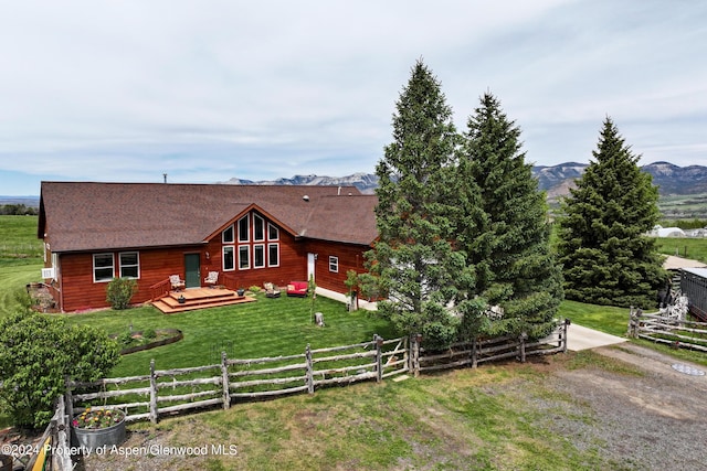 view of front facade with a front yard and a deck with mountain view