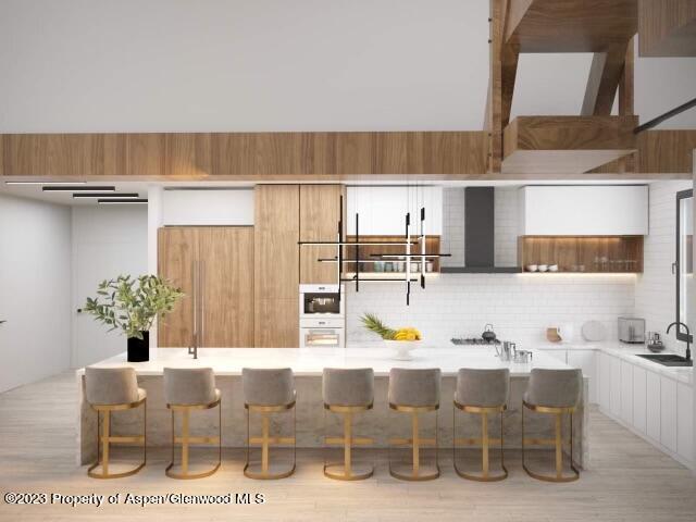 65 Upland Ln Unit 2, Carbondale, CO 81623 - kitchen featuring a kitchen breakfast bar, backsplash, light countertops, and a sink