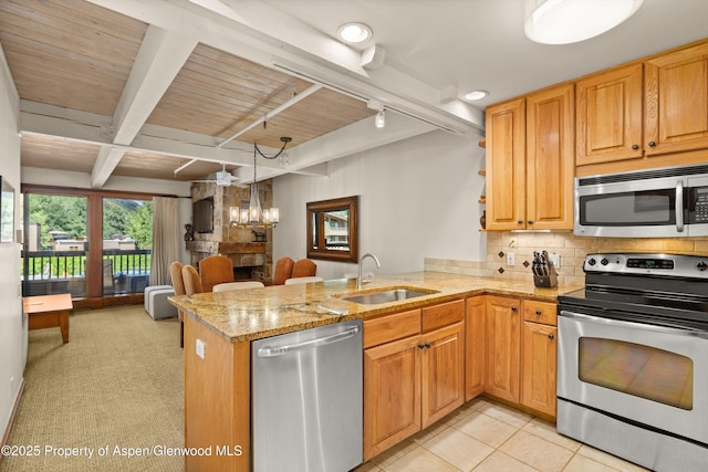 610 S W End St Unit H202, Aspen, CO 81611 - kitchen with stainless steel appliances, a peninsula, backsplash, light stone counters, and a chandelier