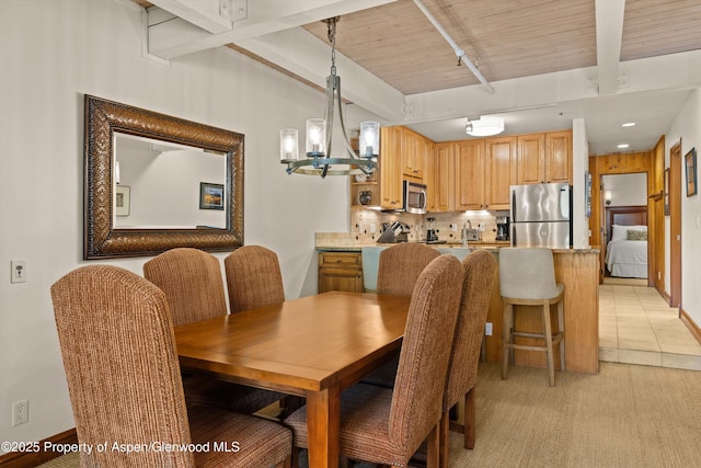 610 S W End St Unit H202, Aspen, CO 81611 - dining space with beam ceiling, a chandelier, and light colored carpet