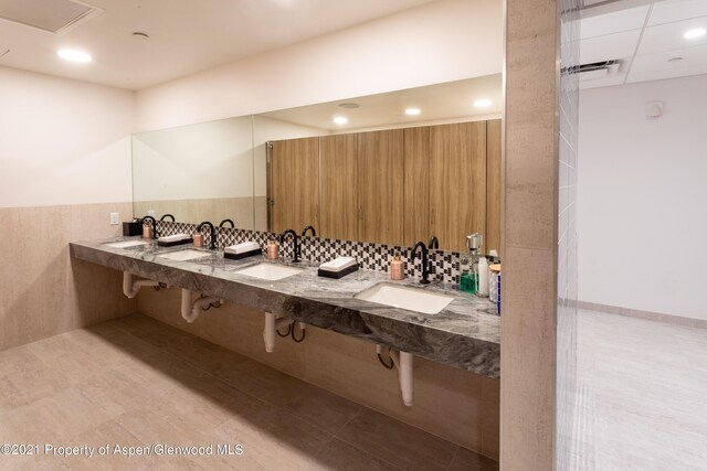 bathroom with double sink and backsplash