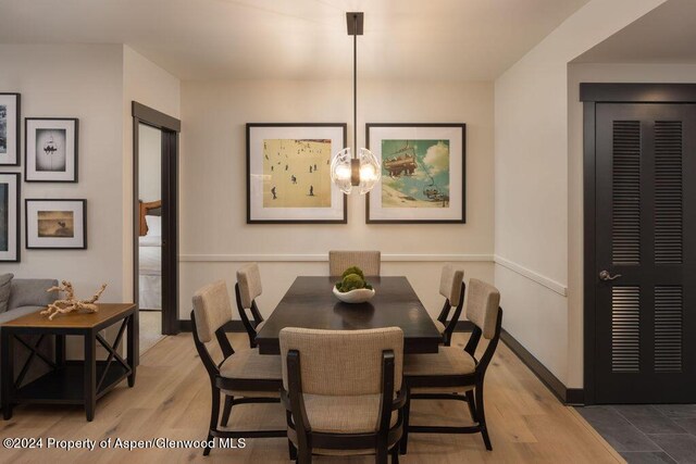 dining area with light wood-type flooring and a chandelier