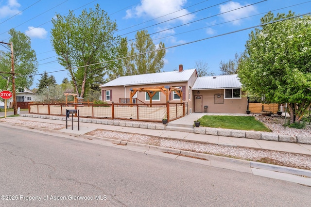235 W 8th St, Craig, CO 81625 - ranch-style home with fence, metal roof, a chimney, and stucco siding