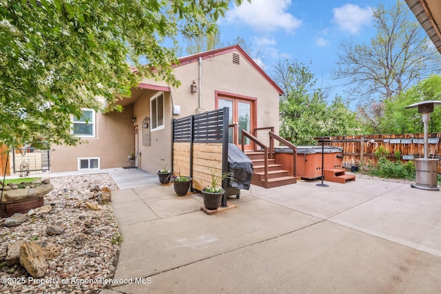 235 W 8th St, Craig, CO 81625 - back of property featuring a hot tub, stucco siding, a patio, fence, and french doors