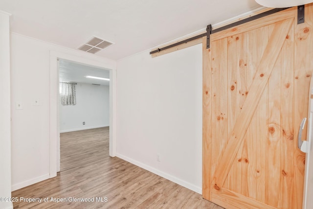 235 W 8th St, Craig, CO 81625 - empty room with a barn door, wood finished floors, and baseboards