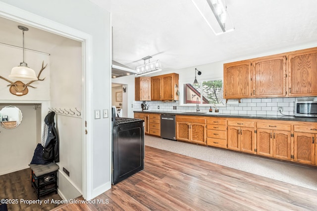 235 W 8th St, Craig, CO 81625 - kitchen featuring appliances with stainless steel finishes, dark countertops, backsplash, wood finished floors, and a sink