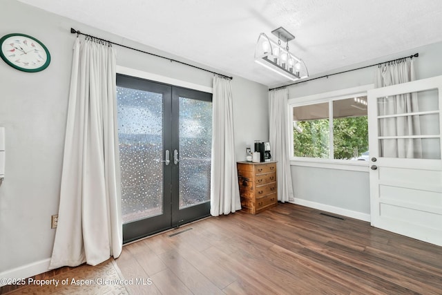 235 W 8th St, Craig, CO 81625 - unfurnished dining area featuring french doors, wood finished floors, and baseboards