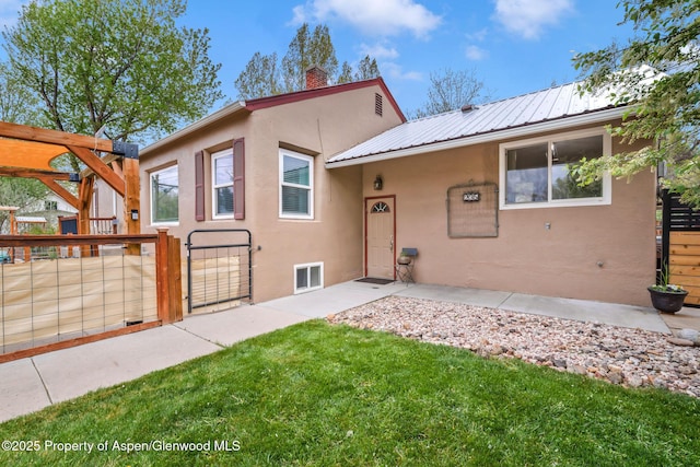 235 W 8th St, Craig, CO 81625 - view of front facade with stucco siding, a gate, a chimney, and metal roof