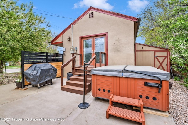 235 W 8th St, Craig, CO 81625 - back of property with a hot tub, stucco siding, a patio area, french doors, and an outbuilding