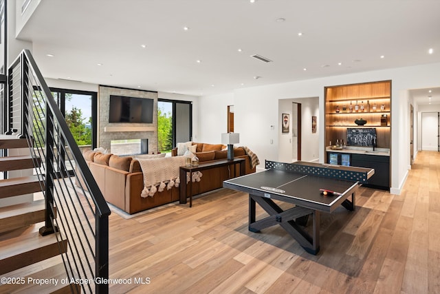 1234 Wood Rd, Snowmass Village, CO 81615 - playroom featuring a bar, light wood finished floors, healthy amount of natural light, recessed lighting, and a multi sided fireplace