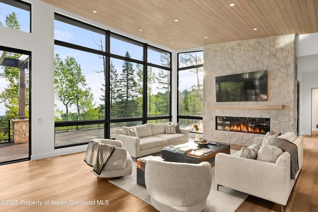 1234 Wood Rd, Snowmass Village, CO 81615 - living area featuring wood ceiling, a stone fireplace, wood finished floors, healthy amount of natural light, and recessed lighting