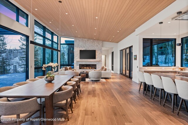 1234 Wood Rd, Snowmass Village, CO 81615 - dining space featuring wood ceiling, recessed lighting, a stone fireplace, light wood-type flooring, and baseboards