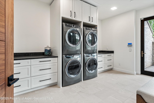 1234 Wood Rd, Snowmass Village, CO 81615 - laundry area with cabinet space, washer and dryer, stacked washer / dryer, light tile patterned flooring, and baseboards