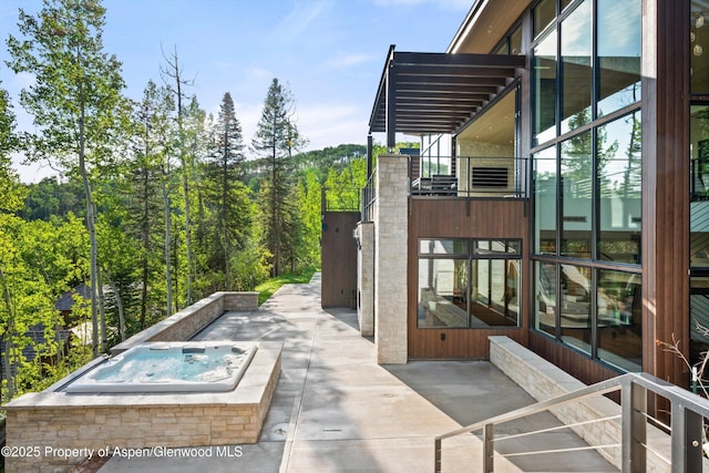 1234 Wood Rd, Snowmass Village, CO 81615 - view of patio with an outdoor hot tub and a wooded view
