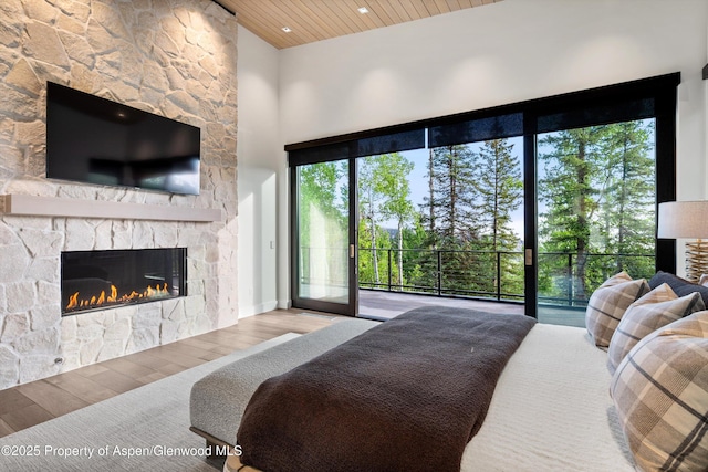 1234 Wood Rd, Snowmass Village, CO 81615 - bedroom with access to exterior, wood finished floors, a fireplace, wooden ceiling, and a high ceiling